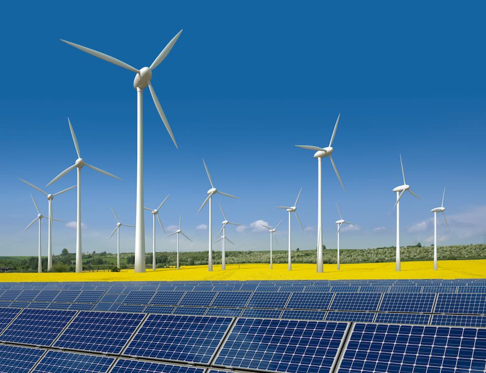 Solaranlagen, Windräder und blühende Felder – Symbolbild für Ökostrom und erneuerbare Energien